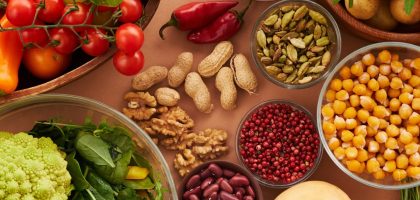 Explore a colorful assortment of healthy ingredients, featuring vegetables, nuts, seeds, and spices in a top view layout.