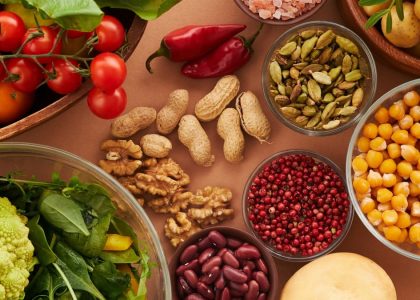 Explore a colorful assortment of healthy ingredients, featuring vegetables, nuts, seeds, and spices in a top view layout.